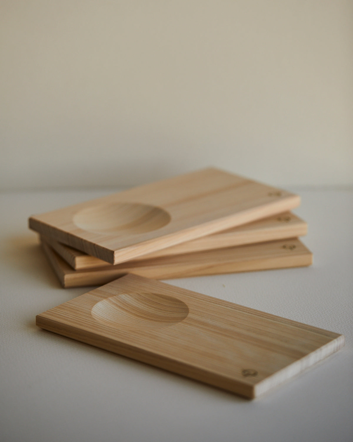 Hinoki sake serving trays stacked, carved hollows facing up
