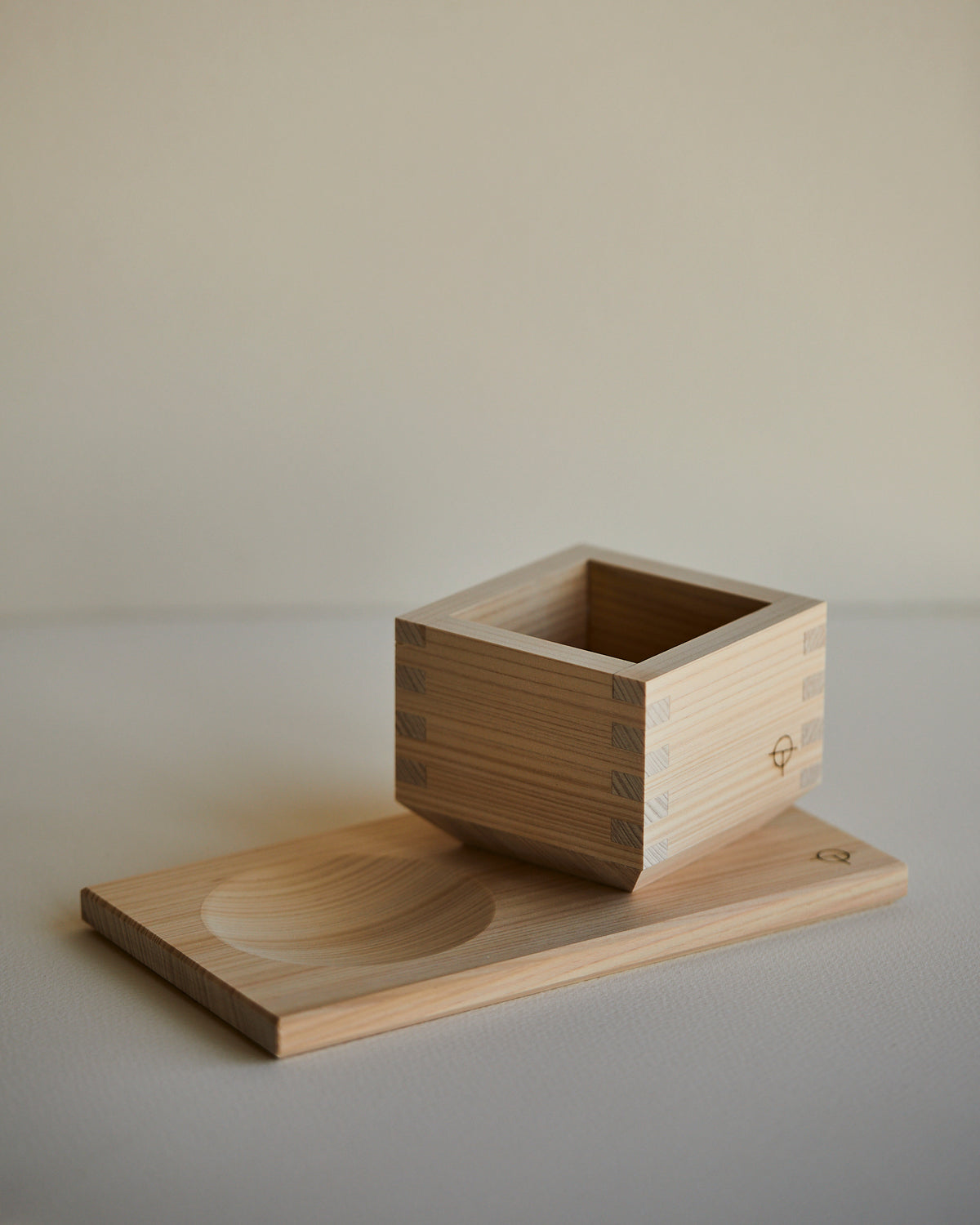 Hinoki sake cup seated on the serving tray, side view