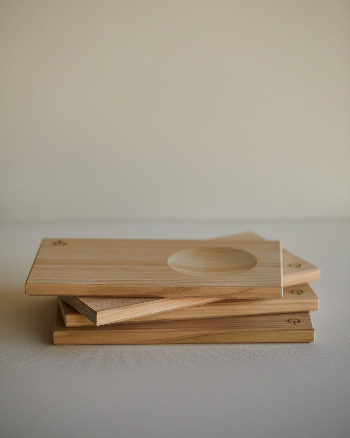 Stack of Hinoki sake serving trays, carved hollows visible